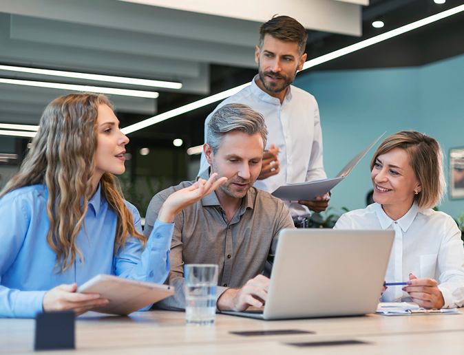 Firemný tím diskutuje nad notebookom o prémiovom internetovom pripojení pre firmy.