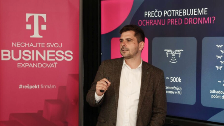 Prednáška odborníka z Telekomu o potrebe ochrany pred dronmi - na pozadí infografika s údajmi o počte komerčných dronov v EÚ.