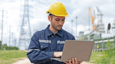 Technik v energetickom prostredí pracuje s notebookom pri monitorovaní zariadení – vizuál služby IoT Platforma od Telekomu.