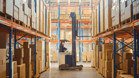 Skladový priestor s regálmi a manipulačnou technikou v prevádzke – vizuál služby IoT Platforma od Telekomu.