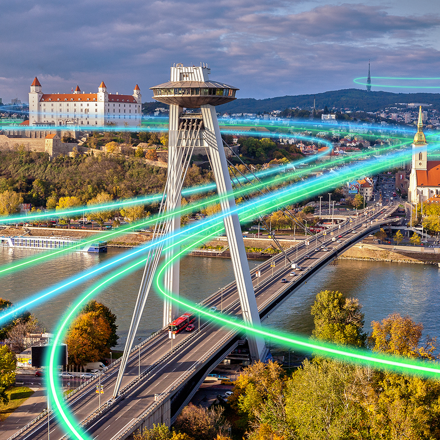 Pohľad na Bratislavský hrad, UFO a most SNP s digitálnymi svetelnými líniami symbolizujúcimi dátové pripojenie – IT:Works od T Business ako riešenie IT služieb a bezpečnosti pre firmy.