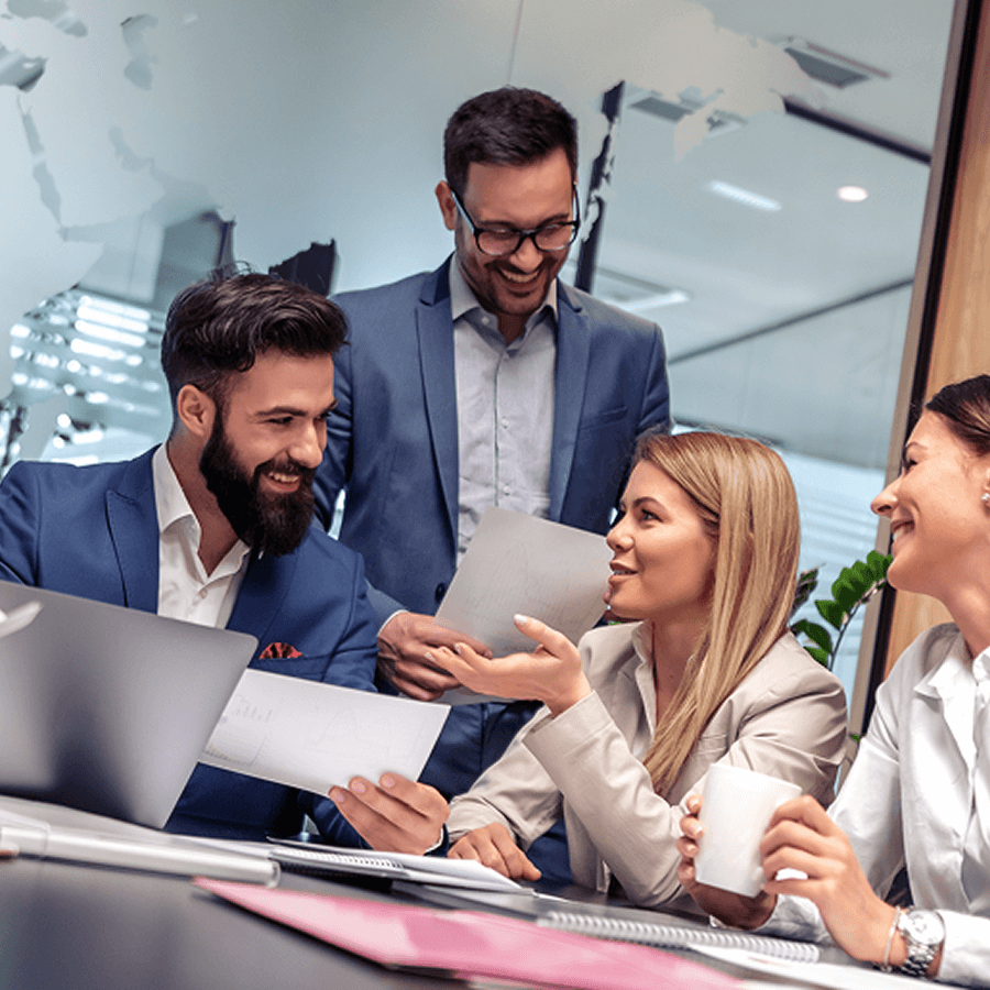 Tím v modernej kancelárii konzultuje dokumenty a dáta pri obchodnom stretnutí – vizuál služby Market Locator od Telekomu.