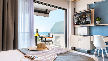 Moderná hotelová izba s otvoreným balkónom a TV obrazovkou s Telekom obsahom. Príklad využitia Business Stream v hoteli.