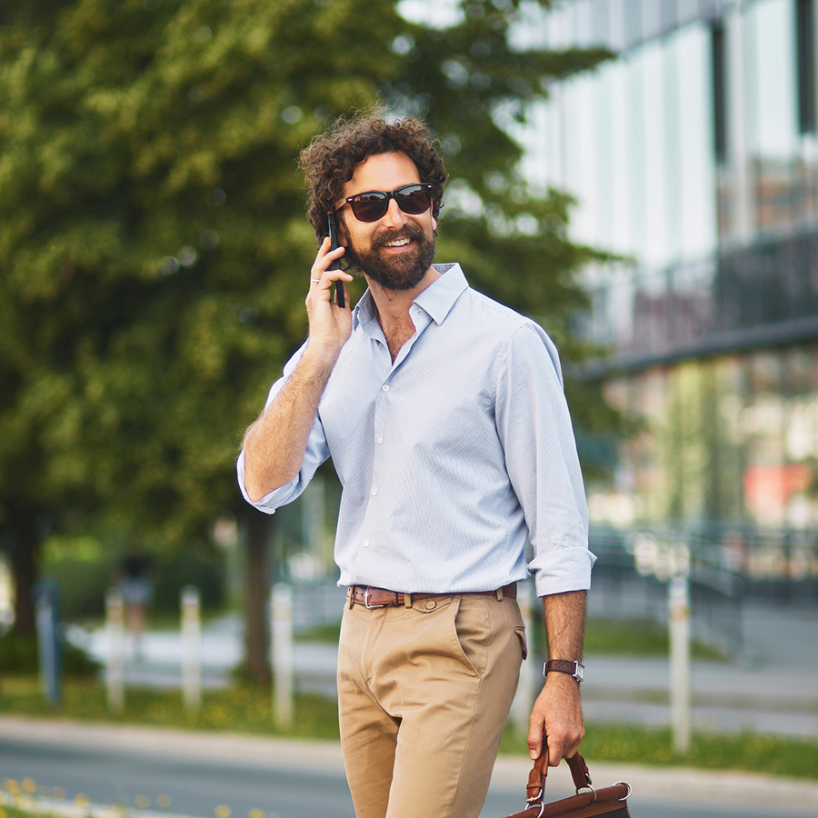 Muž telefonuje počas prechádzky mestom – vizuál reprezentuje mobilné a pevné služby Telekomu pre firemných zákazníkov.